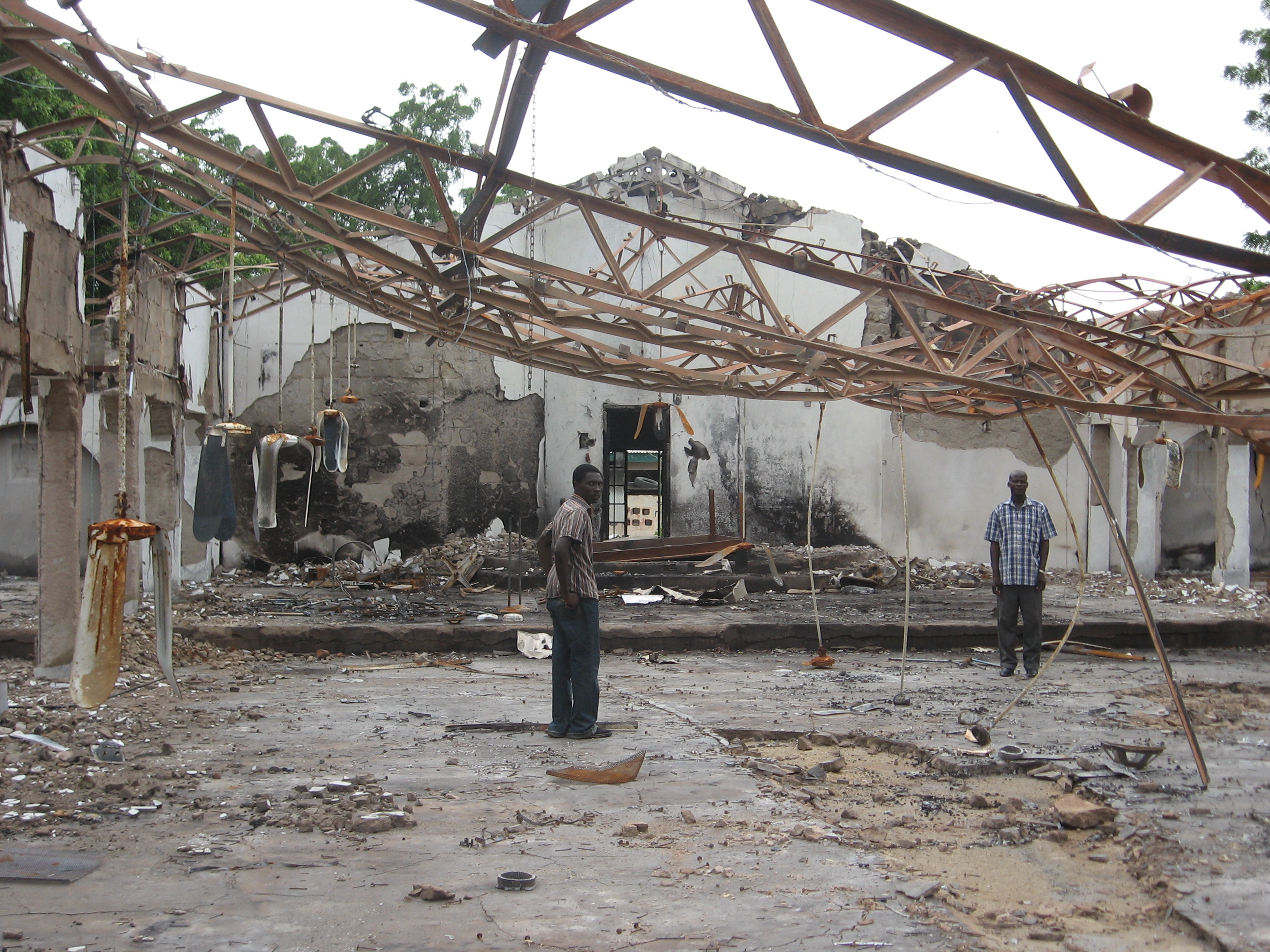 Die Überreste der von Boko Haram ausgebrannten EYN-Kirche in Maiduguri/Wulari; Gemeindemitglied (links) und Gemeindepfarrer Yuguda Z. Mdurvwa. Foto: Mission 21/Jochen Kirsch, Meehyun Chung.